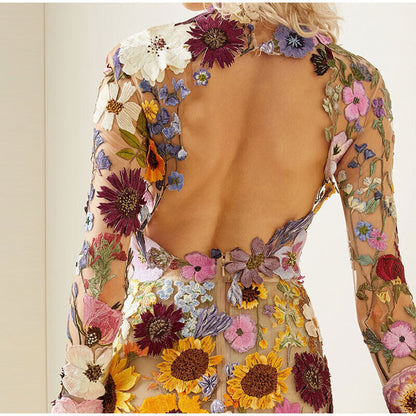 Rückenfreies Kleid mit bunten Blumenstickereien, transparentes Material, elegantes Design.