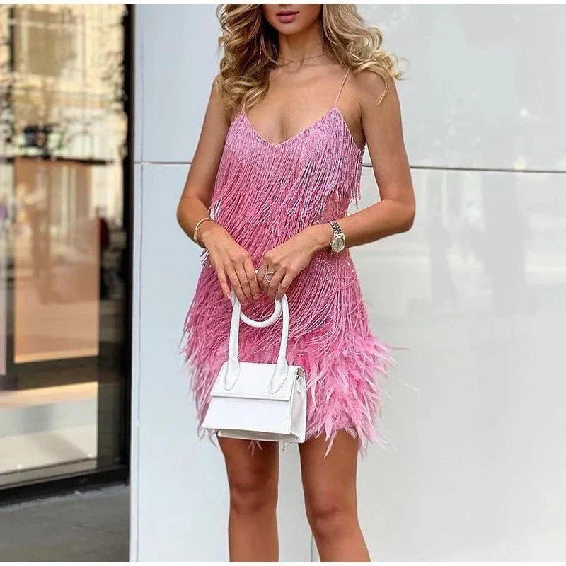 Frau in rosa Fransen-Cocktailkleid mit weißer Handtasche, elegantes Abendoutfit.