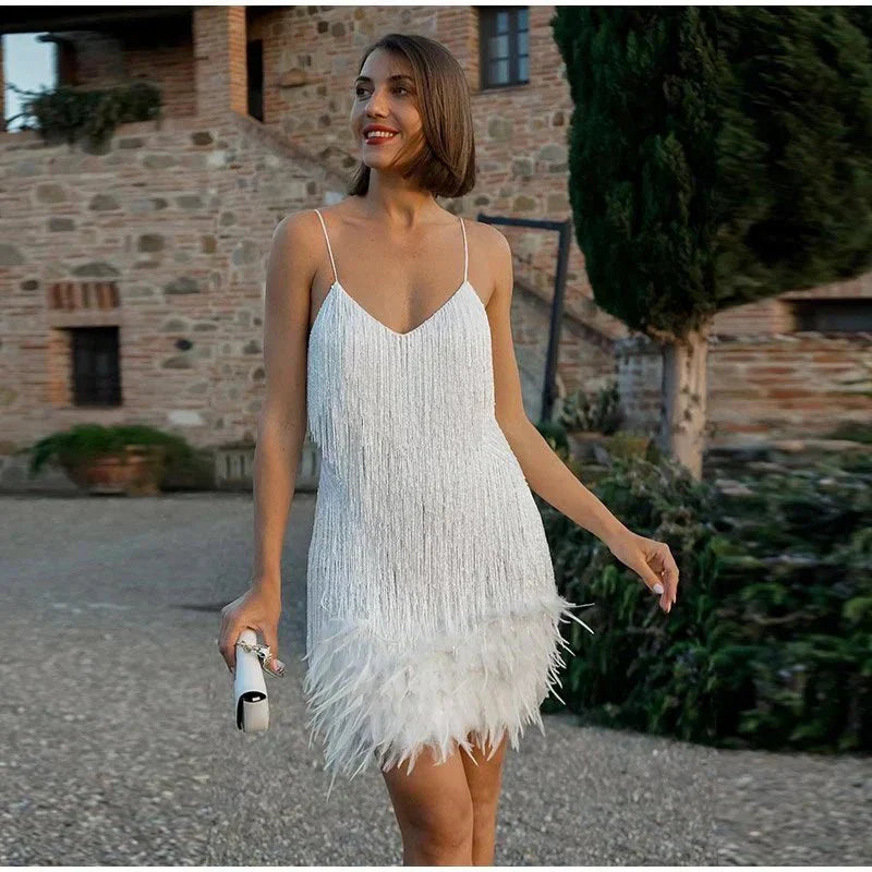 Frau im weißen Cocktailkleid mit Federn, elegantes Abendoutfit, draußen, stilvoll.