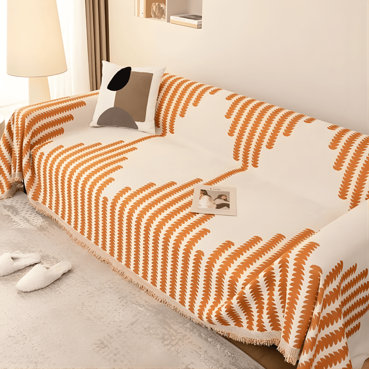 Överdraget i orange och krämvitt draperat över en soffa, sett uppifrån i vinkel, med fransar längs kanten. 4