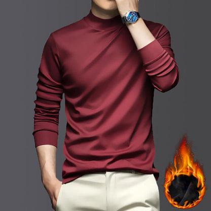 Mann in rotem Langarmshirt, beige Hose, blaue Uhr, Flammensymbol, stilvolle Herrenmode.