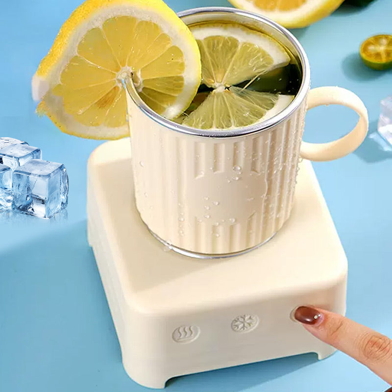 Beiger Becher mit Zitronenscheiben auf elektrischem Getränkewärmer, blaue Oberfläche.