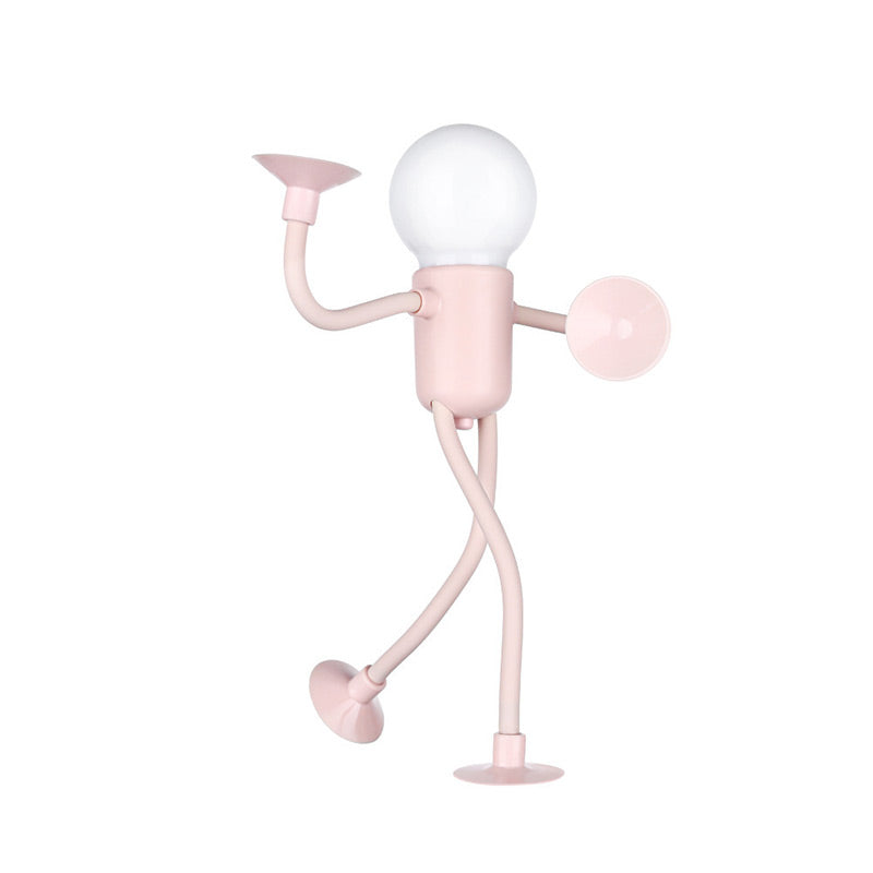 Rosa lampfigur med runt vitt ljushuvud, ena armen lyft och benen i gångställning, på vit bakgrund. 3