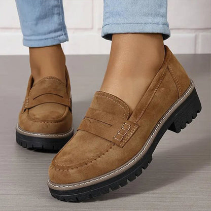 Bruna loafers med synliga vita sömmar och tjock svart sula, burna med ljusblå jeans. 5