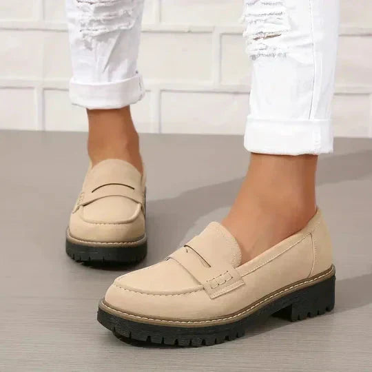 Beiga loafers med grov svart sula, burna med uppvikta vita jeans, sedda från sidan och framifrån. 7