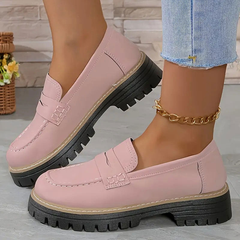 Rosa loafers i slätare yta med tjock svart plattformssula, burna med guldig fotkedja och uppvikta jeans. 11