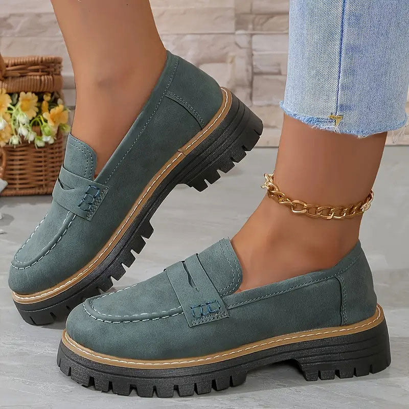 Gröngrå loafers med tjock plattformssula och brun sulkant, burna med guldig fotkedja och urtvättade jeans. 15