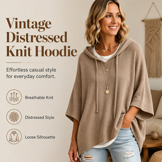 Leende kvinna i beige oversize stickad huvtröja med dragsko, jeans och långa halsband, med ikoner för stickat, slitna detaljer och vid passform. 1