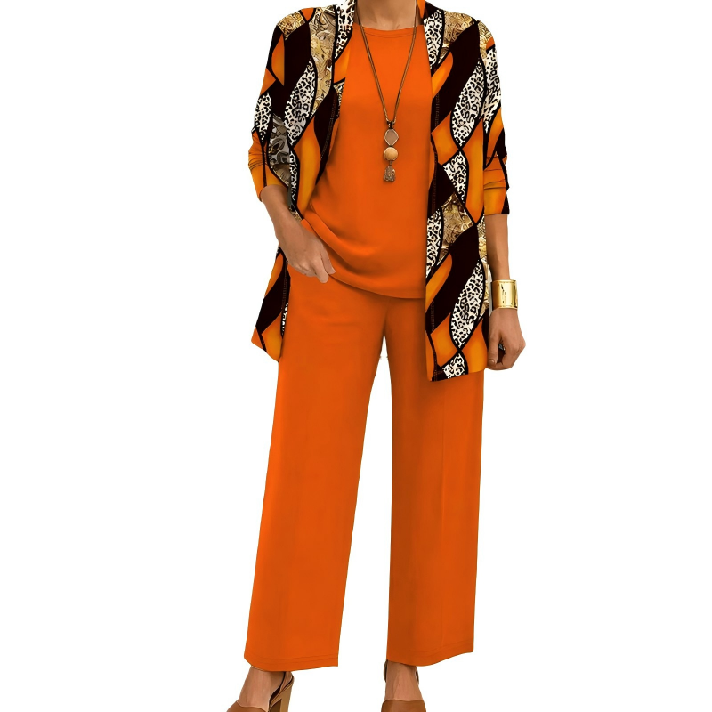 Modell i orange set där koftan har vågiga fält med leopardmönster, matchande topp och vida byxor samt halsband. 9
