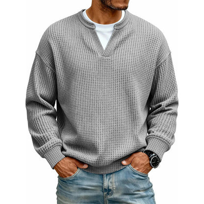 Våffelstickad långärmad topp i mellangrått med V-ringad fejkkrage över vitt linne, buren med jeans och armbandsur. 17