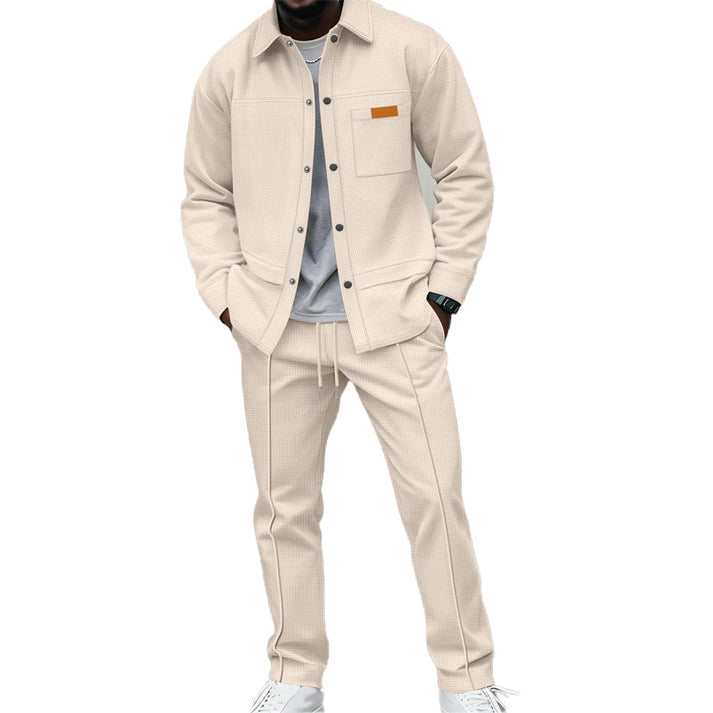 Man i beige set med uppknäppt skjorta över grå t-shirt och byxor med dragsko 3