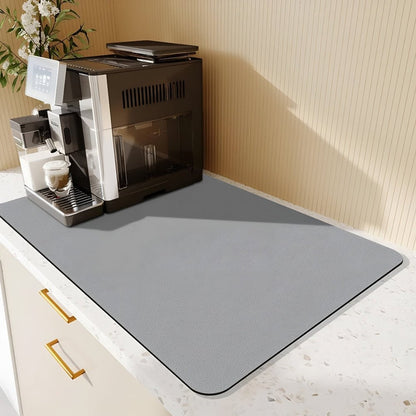 Ljusgrå matta på en terrazzobänk bredvid en svart kaffemaskin med pekskärm, framför en randig beige vägg. 8