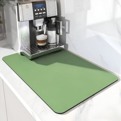 Ljusgrön matta med rundade hörn framför en kaffemaskin på en vit marmorbänk, närbild på maskinens frontpanel. 6