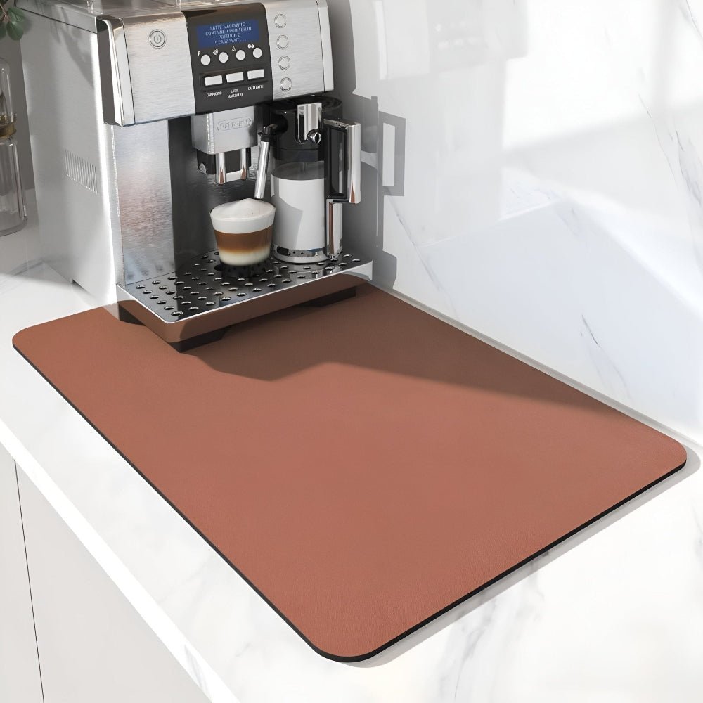 Terrakottabrun matta på en vit marmorbänk framför en kaffemaskin med en latte i glaset. 10