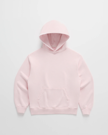 Ljusrosa hoodie sedd framifrån, med känguruficka och vit dekorsöm längs ena huvkanten. 3