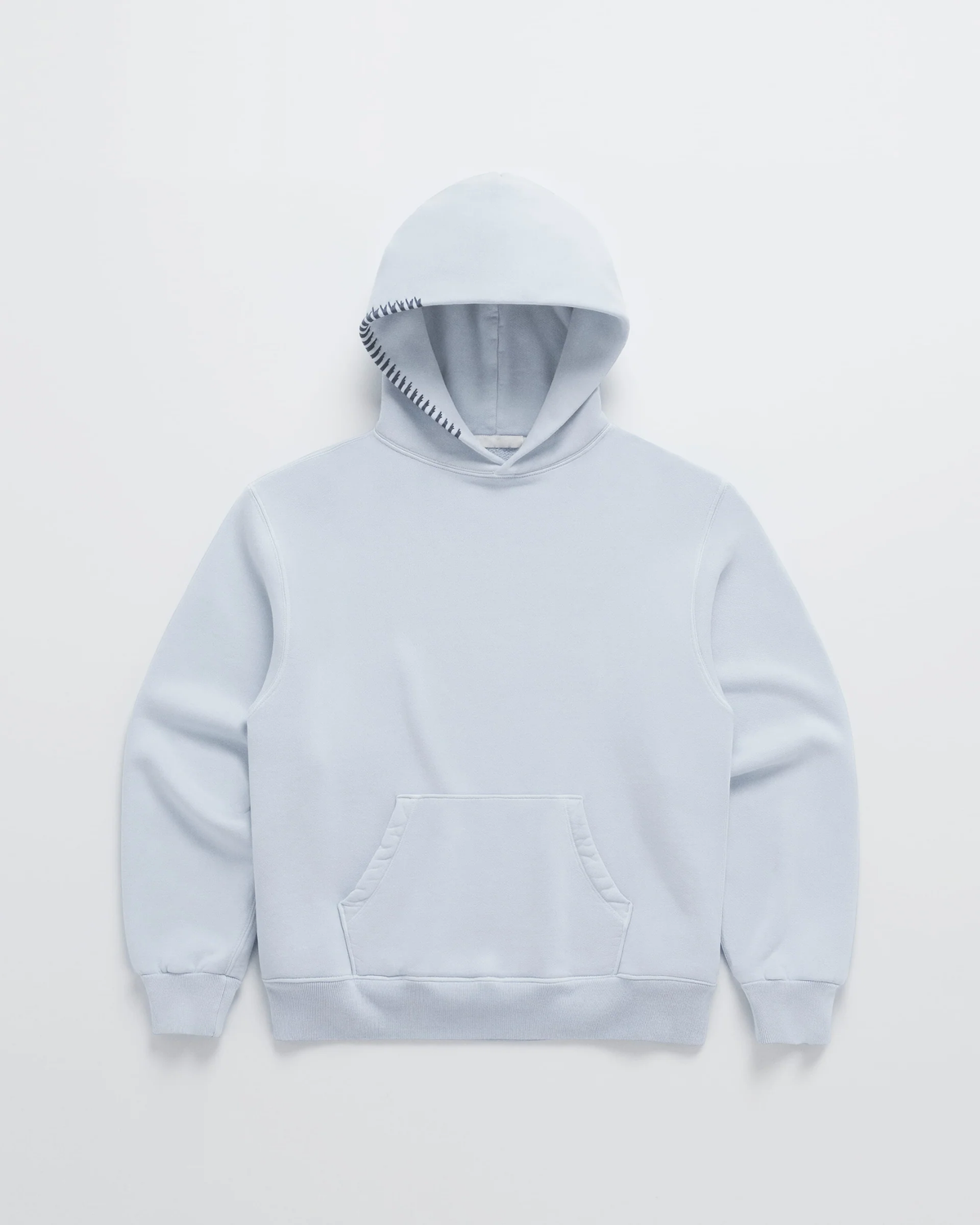 Ljusblå hoodie sedd framifrån, med känguruficka och mörkblå dekorsöm längs kanten på huvan. 4