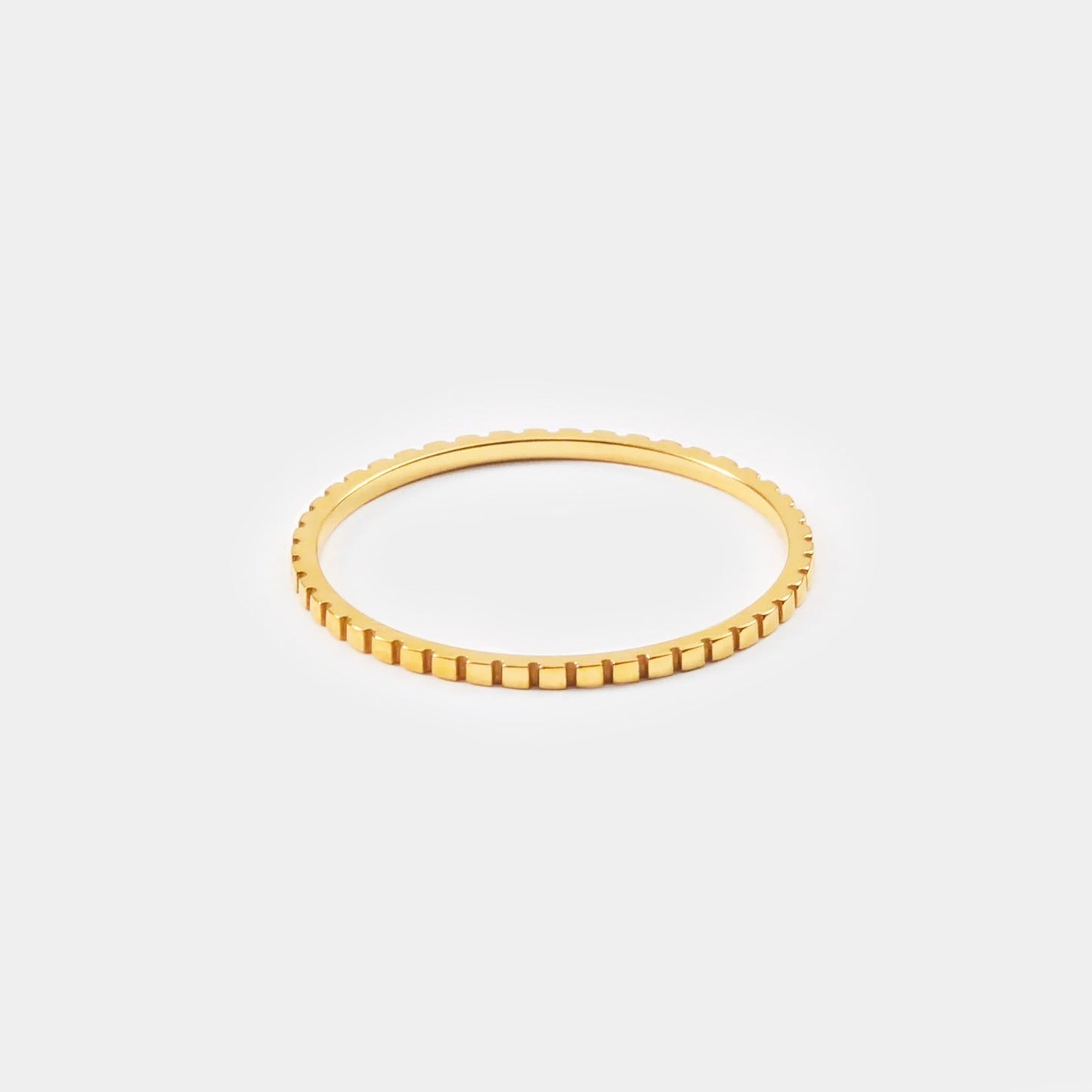 Dünner goldener Ring mit geriffeltem Design, eleganter Schmuck, minimalistischer Stil.