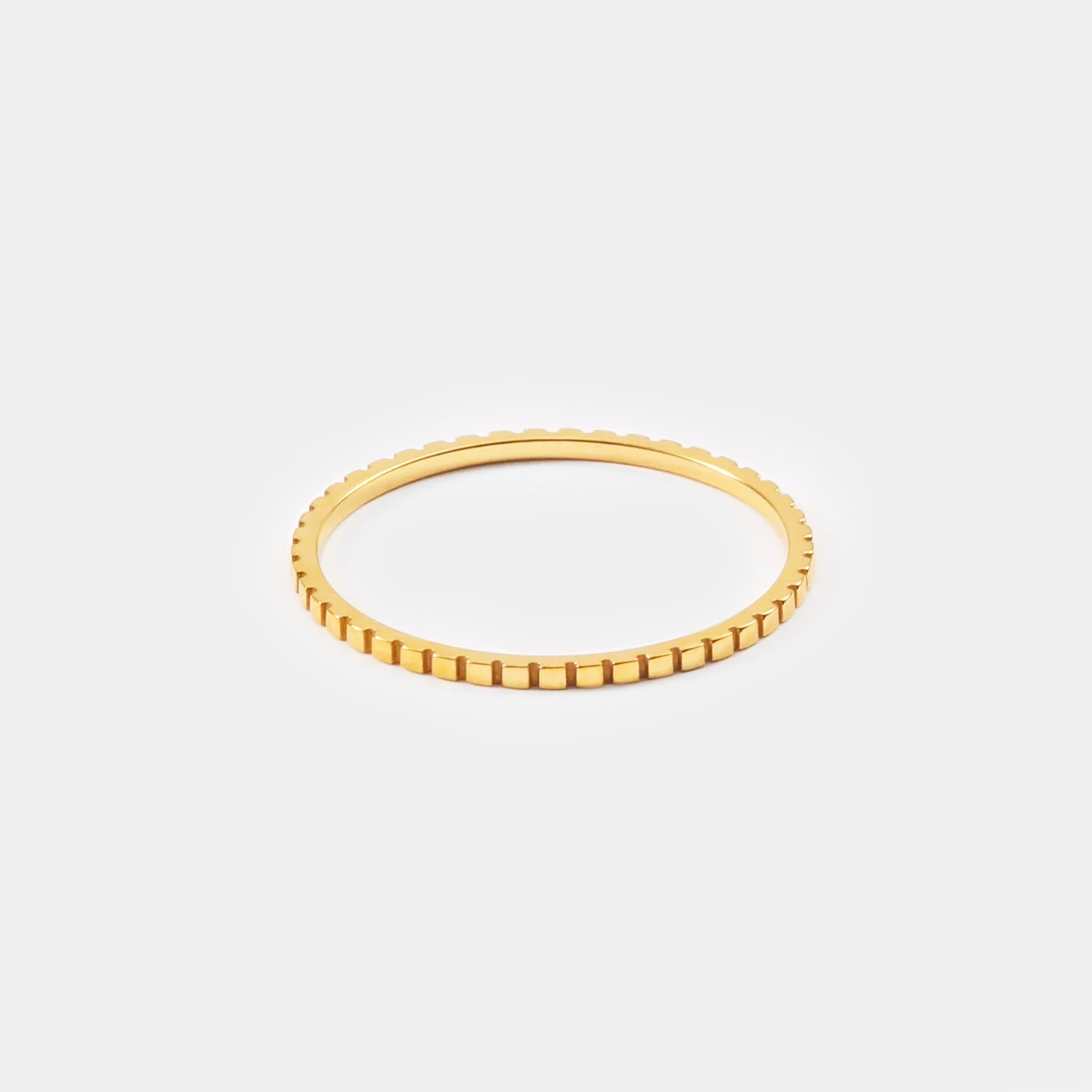 Dünner goldener Ring mit geriffeltem Design, eleganter Schmuck, minimalistischer Stil.