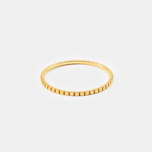 Dünner goldener Ring mit geriffeltem Design, eleganter Schmuck, minimalistischer Stil.