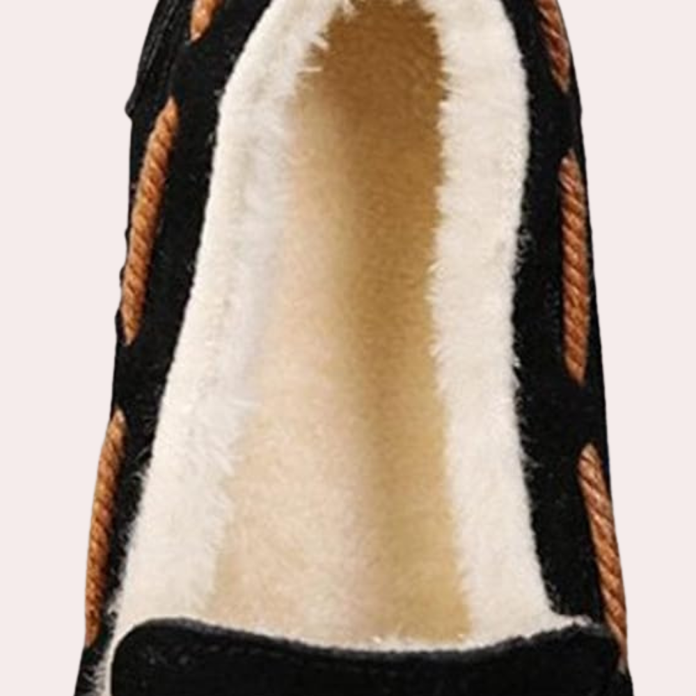 Schwarzer Mokassin mit braunen Details und weißem Futter, bequeme Winter-Hausschuhe.