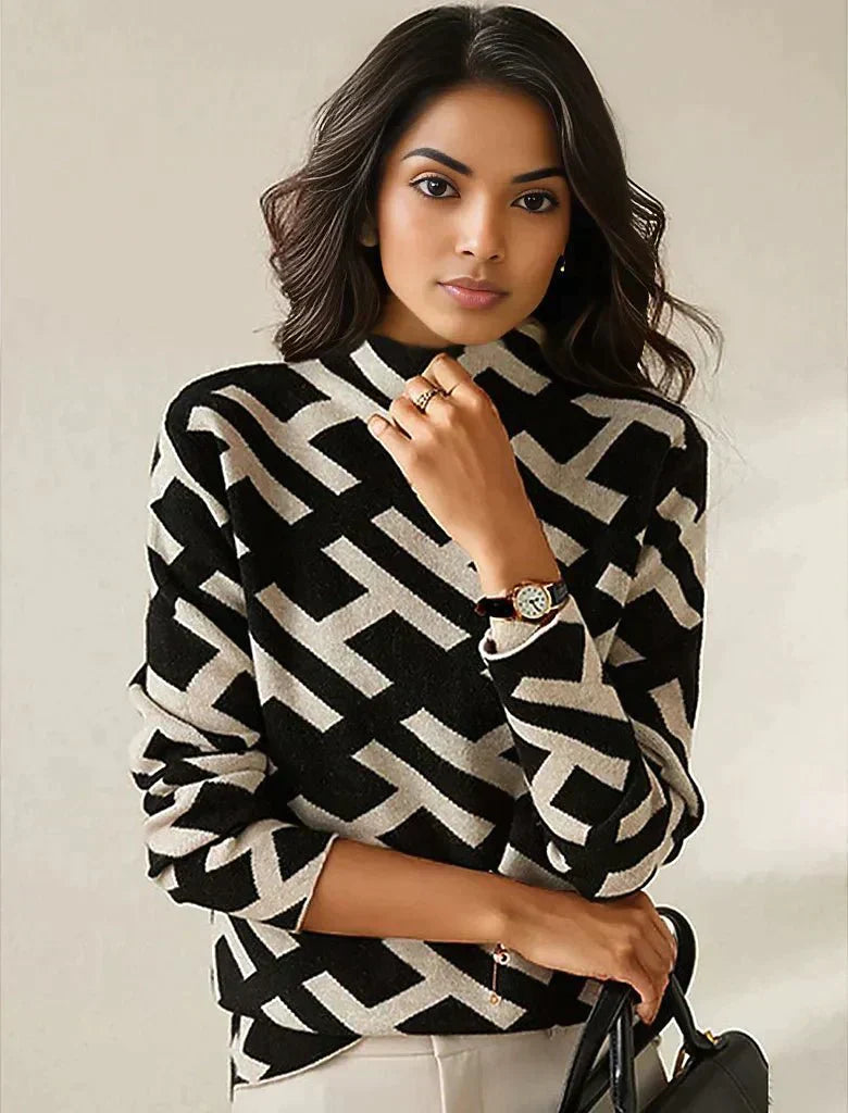 Frau trägt schwarz-weiß gemusterten Pullover, geometrisches Design, eleganter Look.