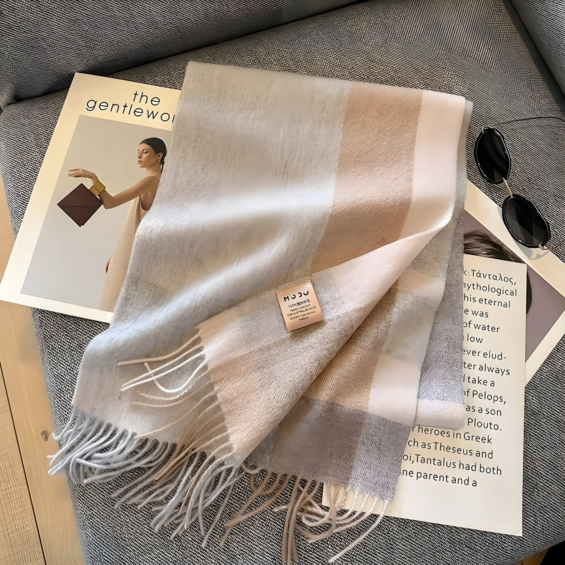 Beige-grauer Wollschal mit Fransen auf Sofa, stilvoll, warm, modisch, Accessoire.