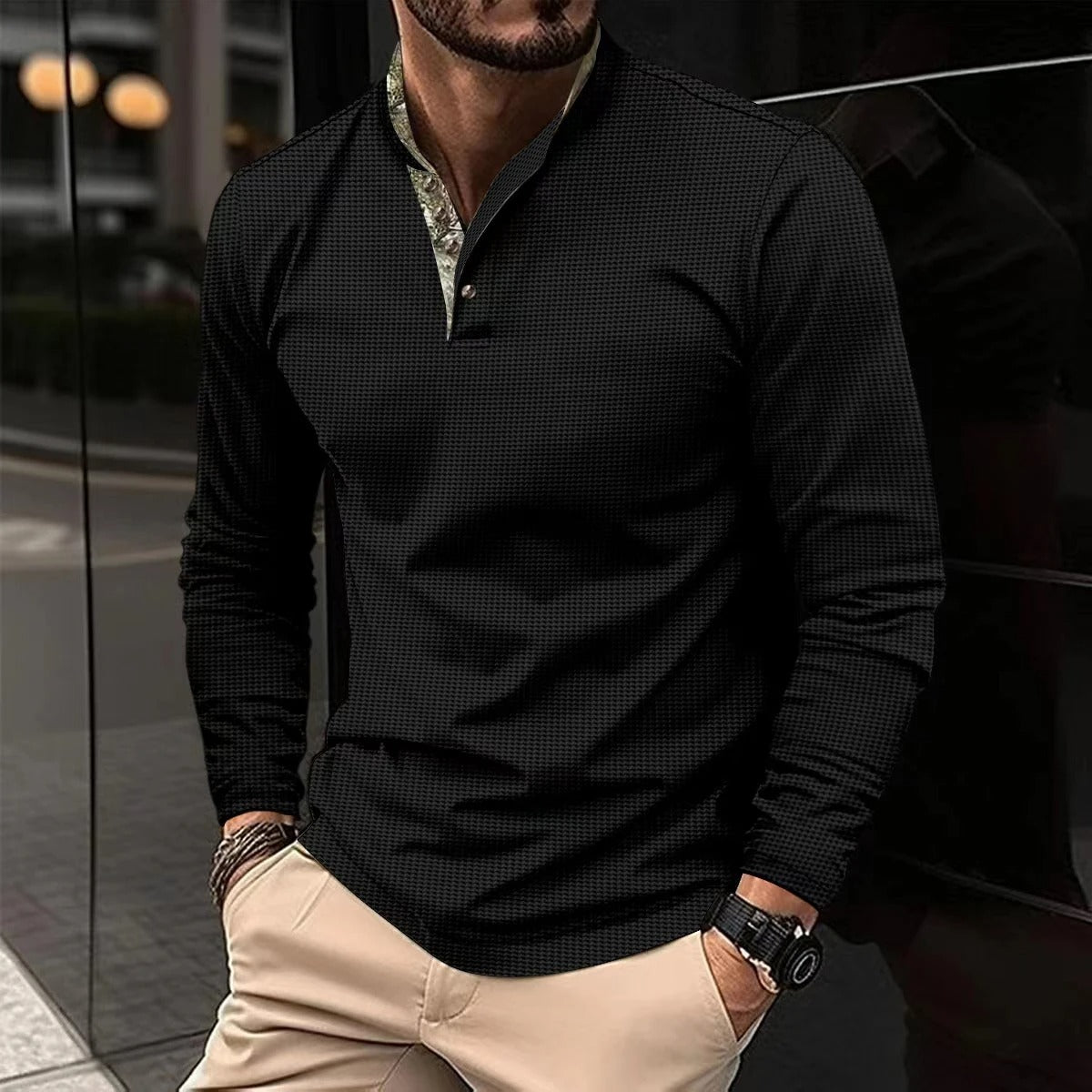 Mann in schwarzem Langarmhemd, Stehkragen, modern, elegant, Herrenmode, urbaner Stil.