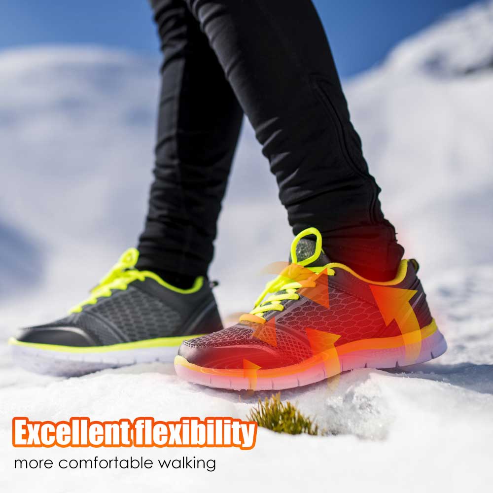 Person mit schwarzen Sportschuhen und gelben Schnürsenkeln im Schnee, flexible Sohle, Winterwandern.