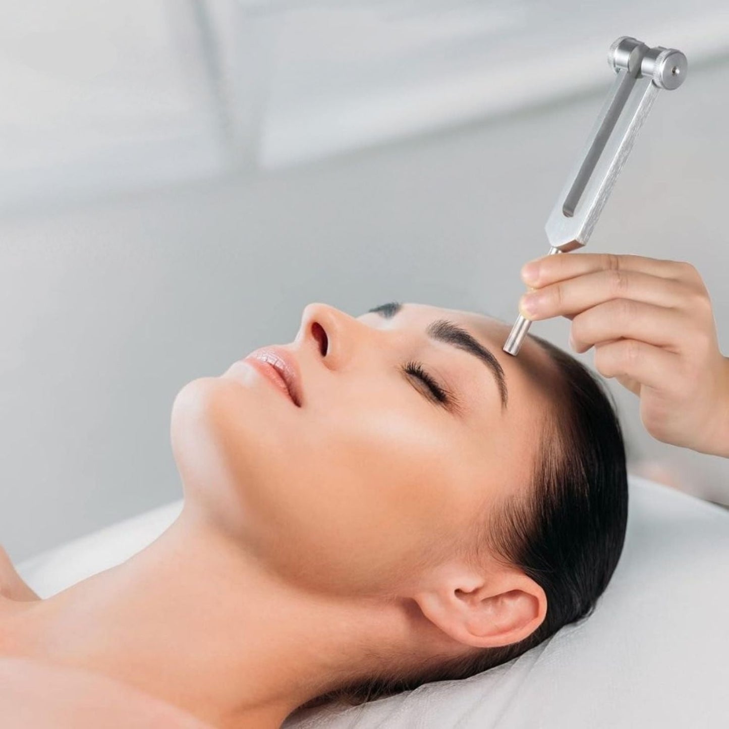 Frau erhält Gesichtsbehandlung mit Stimmgabel, Wellness, Entspannung, Hautpflege.