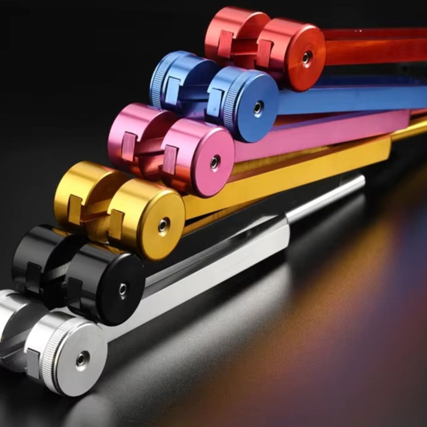 Bunte Aluminium-Stimmgabeln auf schwarzem Hintergrund, Musiktherapie-Instrumente.