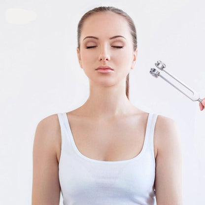 Frau bei Stimmgabeltherapie, Entspannung, Wellness, weiße Kleidung, geschlossene Augen.