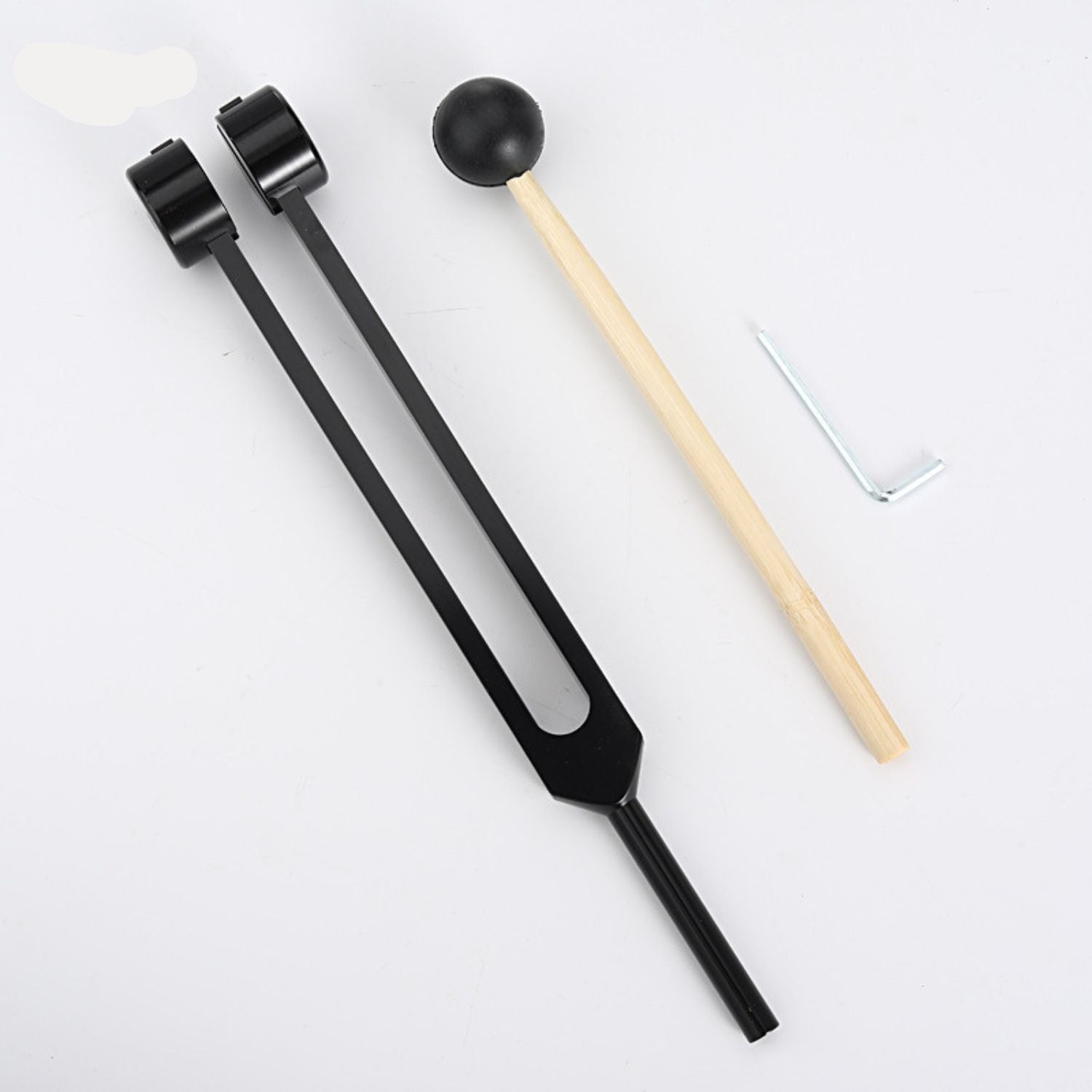 Schwarzes Stimmgabel-Set mit Holzklöppel und Inbusschlüssel auf weißem Hintergrund.