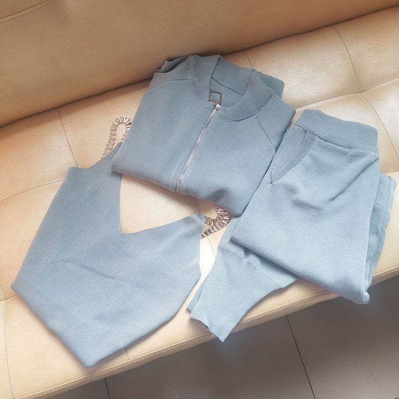 Graues Damen-Trainingsanzug-Set aus Baumwolle, bestehend aus Jacke und Hose, auf Sofa.
