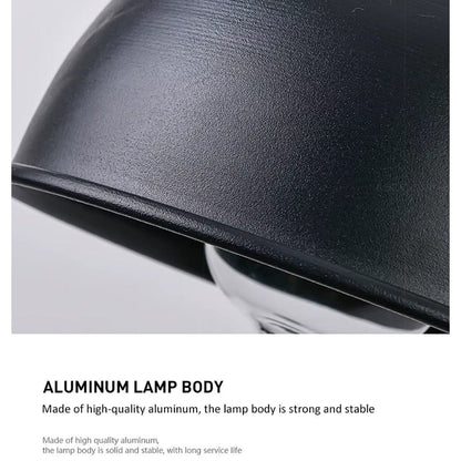 Närbild på kanten av en svart lampskärm med matt, finkornig yta, med text om aluminiumstomme. 17