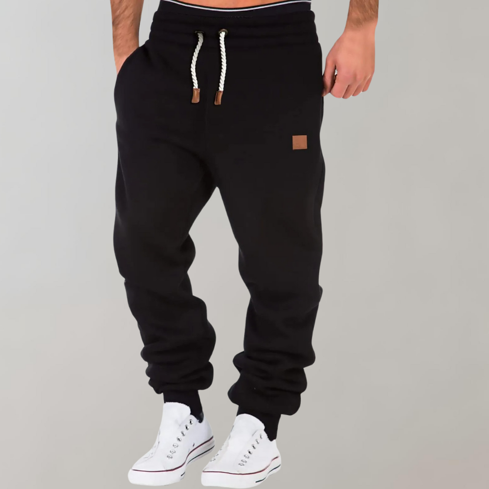 Svarta joggerbyxor med vit dragsko och ribbade benslut, burna med vita sneakers 1