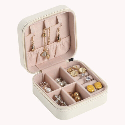 Weiße Schmuckbox mit Fächern, Ohrringen und Ketten, ideal zur Schmuckaufbewahrung.