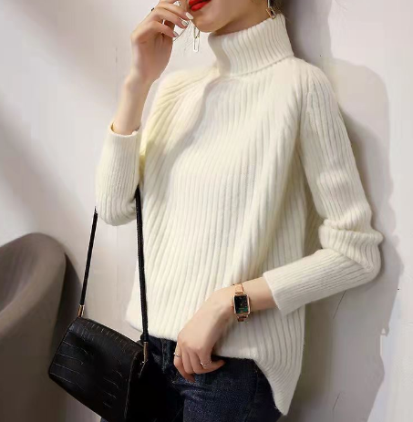 Frau trägt weißen Rollkragenpullover aus Strick, schwarze Handtasche, modisch, elegant.