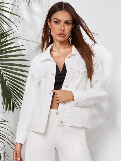 Frau in weißer Jeansjacke, einreihig, lässig, modisch, vor tropischem Hintergrund.