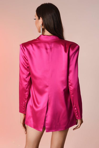 Frau in pinkem Satinblazer mit langen Ärmeln, eleganter Mode, Rückansicht.