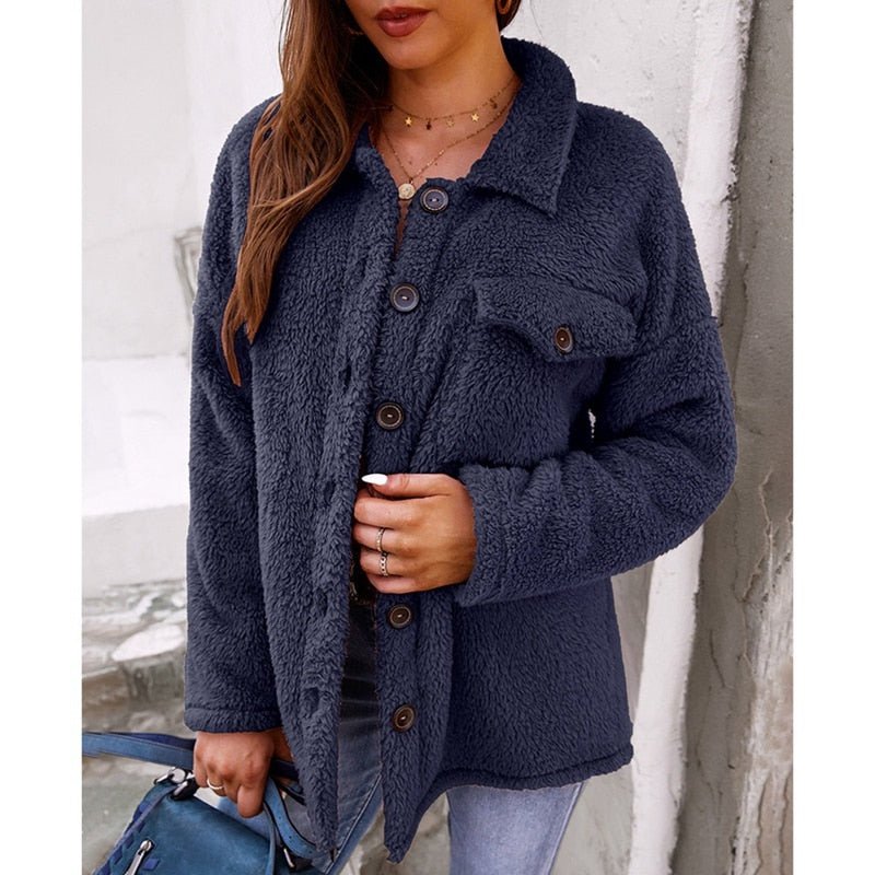Frau in dunkelblauer Fleecejacke mit Knöpfen und Revers, lässiger Herbststil.