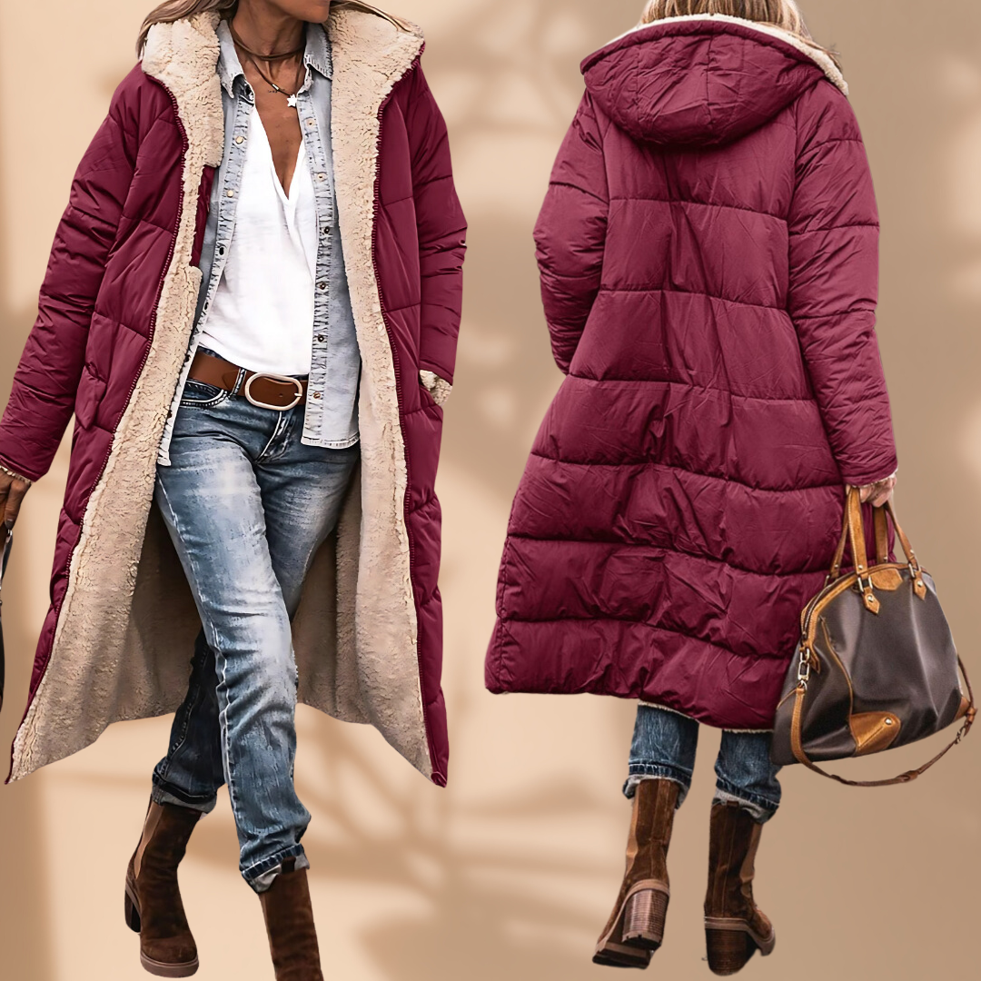 Vinröd lång quiltad jacka med beige teddyfoder, framsida öppen över jeansskjorta och baksida med huva, buren med brun handväska. 1