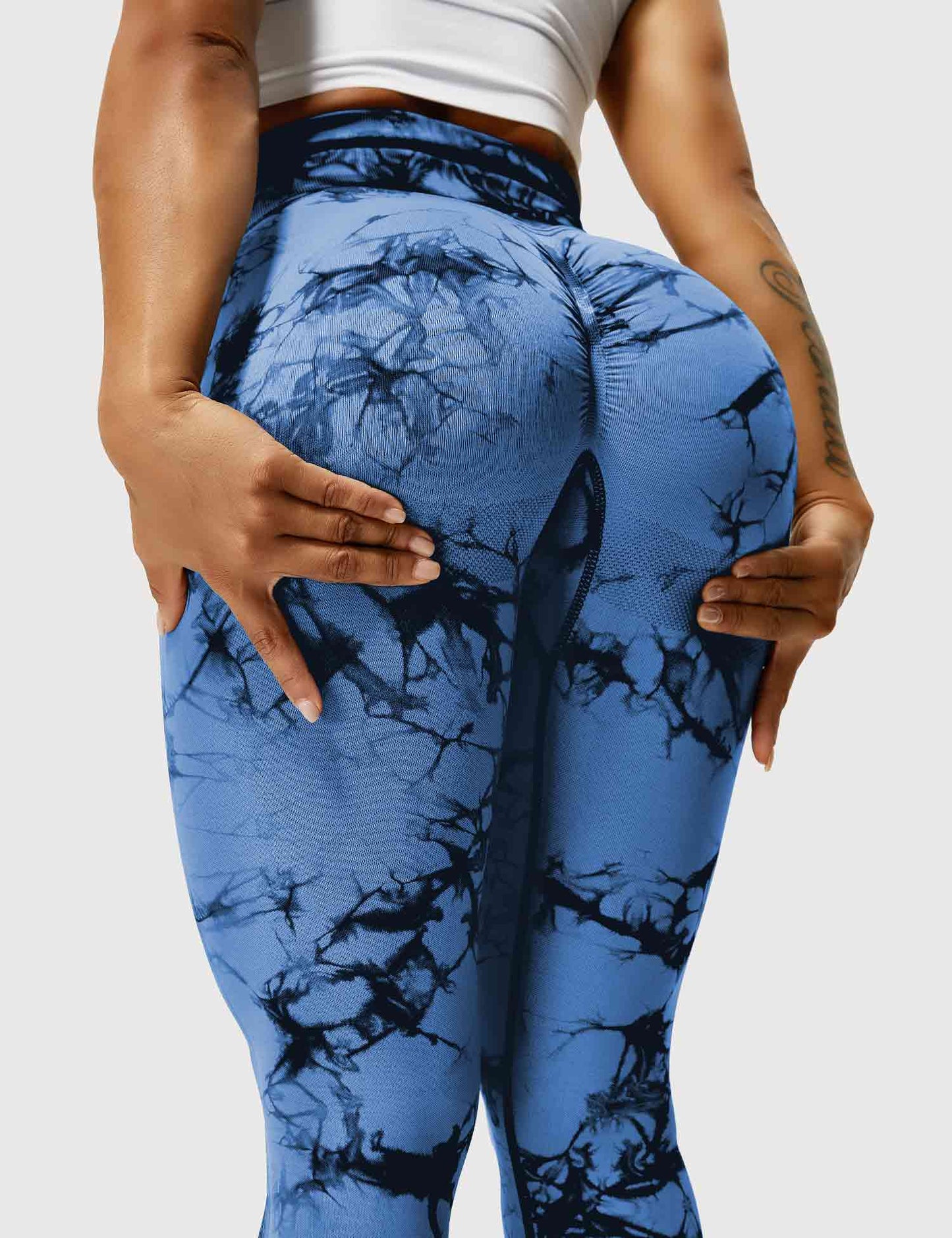 Frau in blauen Batik-Leggings, Sportbekleidung, Fitnessmode, elastisch, bequem.