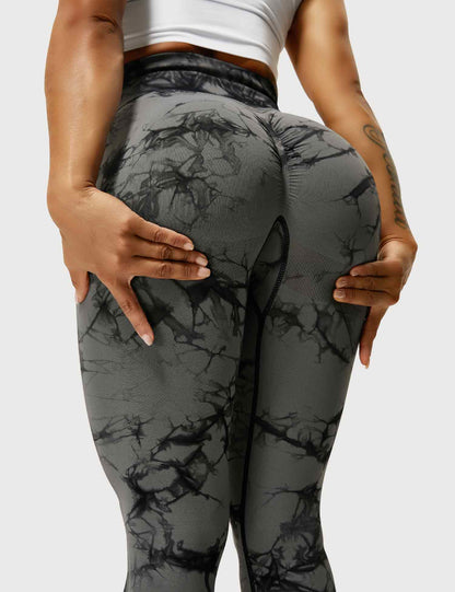 Frau in schwarz-grauen Leggings mit Marmormuster, Sportbekleidung, Fitnessmode.