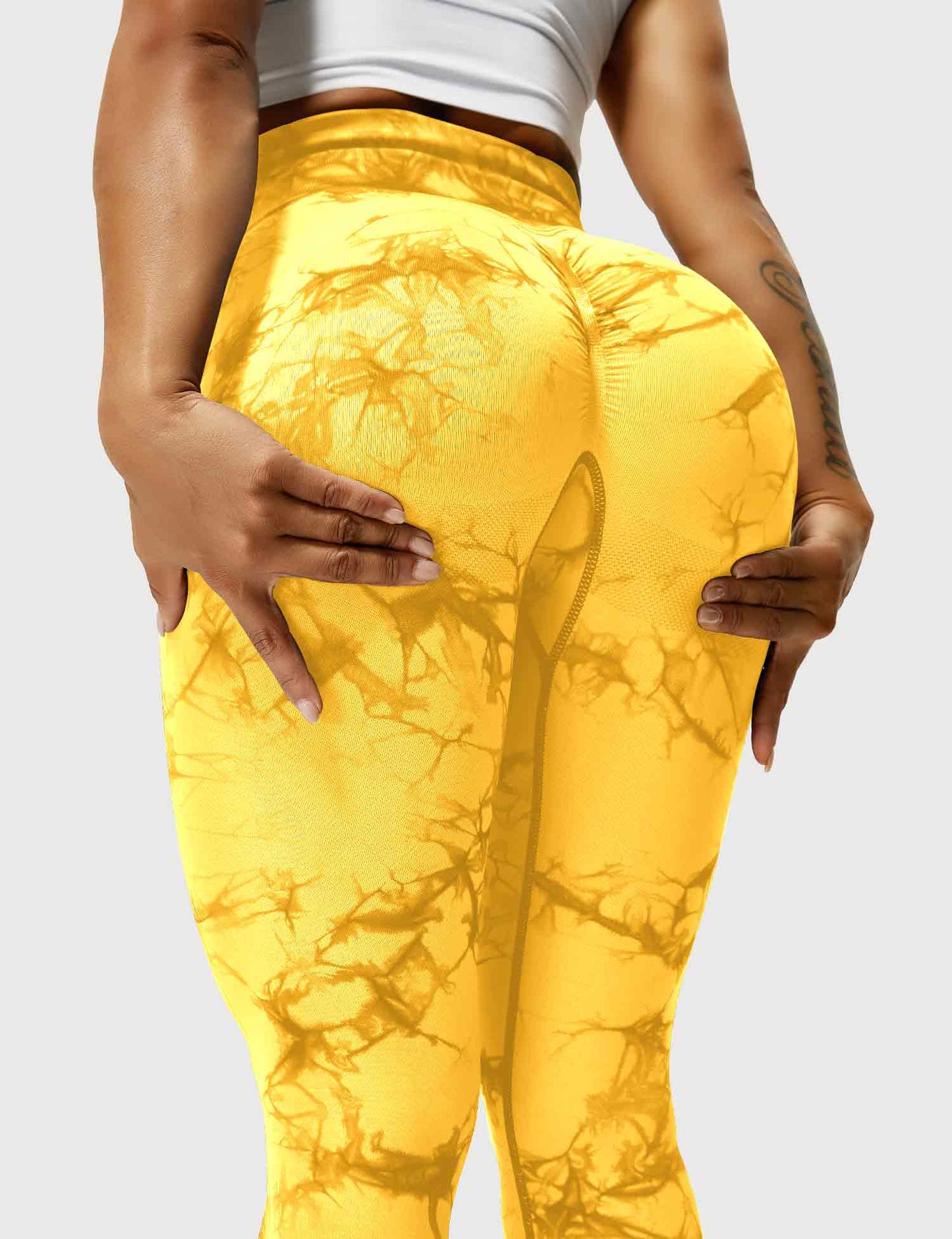 Frau in gelben Leggings mit Marmormuster, Sportbekleidung, Fitnessmode, elastisch, bequem.