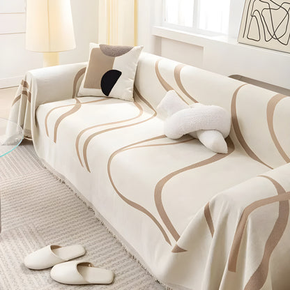 Beige Sofa mit abstraktem Muster, Kissen und Hausschuhen, modernes Wohnzimmer, skandinavisches Design.
