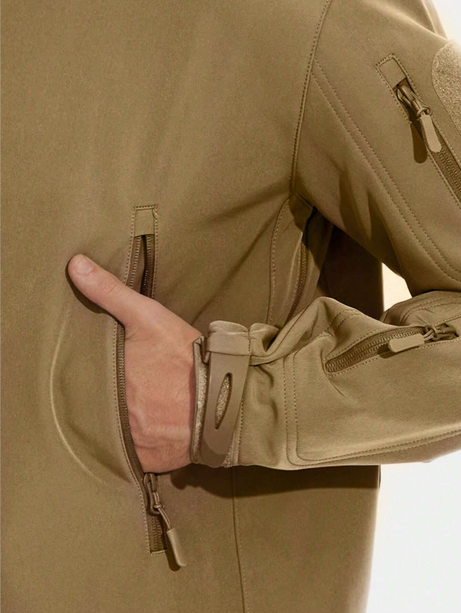 Närbild på beige jackas dragkedjefick där en hand är nedstucken, med ärmslut och ärmficka i fokus. 13