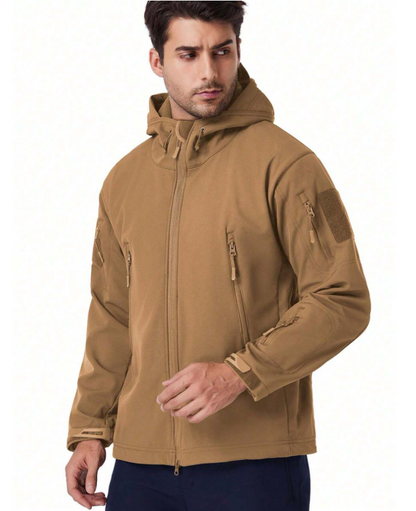 Man i beige jacka med huva och dragkedjefickor, vänd åt sidan, sedd framifrån i halvfigur. 16